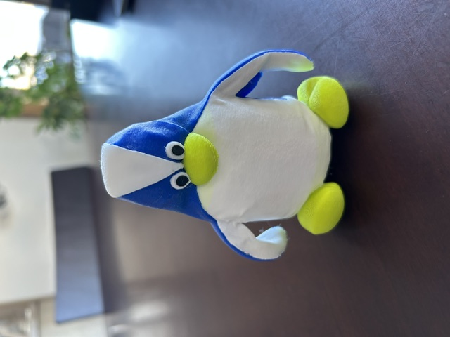 After: 3D-printed replica of the penguin — blue and white body, yellow-green beak and feet, natural plastic finish