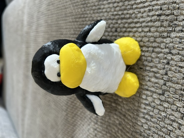 After: 3D-printed replica of the black and white penguin with yellow beak and feet, natural plastic finish