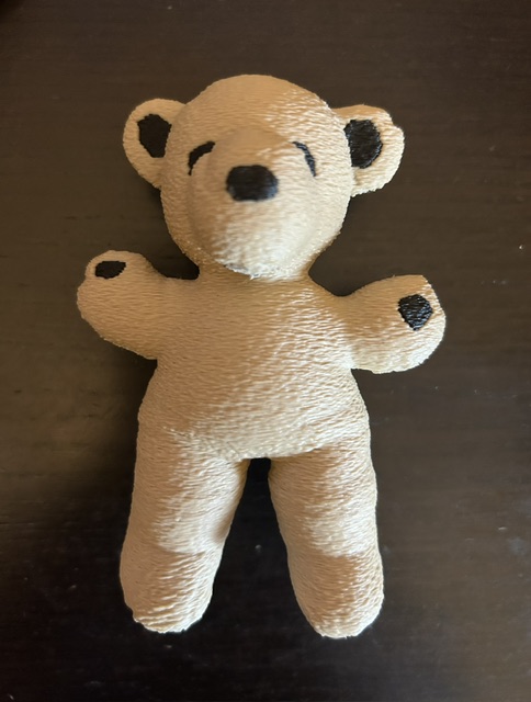 After: 3D-printed replica of the tan teddy bear with dark brown ear and paw details, natural plastic finish